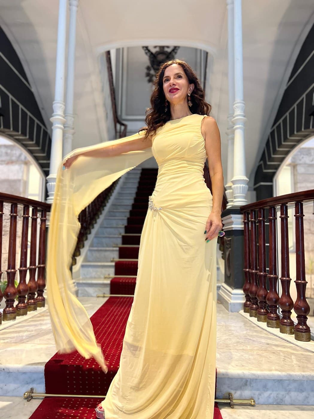 Eva Amieva en una escalinata con vestido amarillo